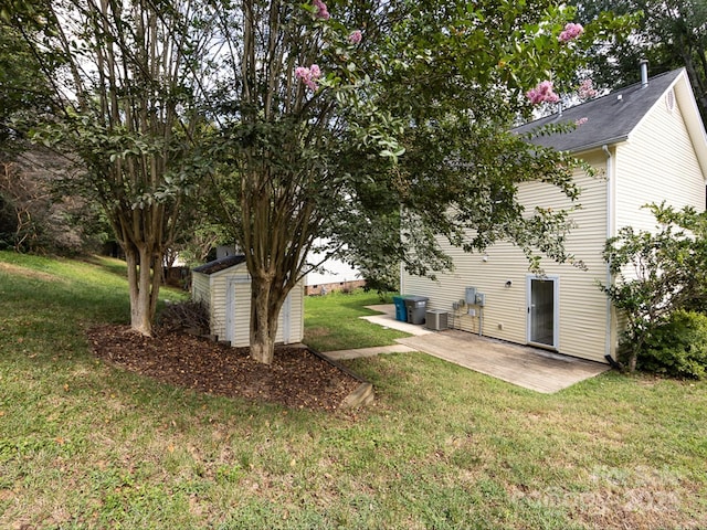 view of yard with central air condition unit, a patio, and a storage shed