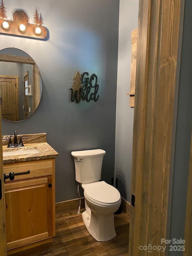 bathroom featuring vanity, wood-type flooring, and toilet