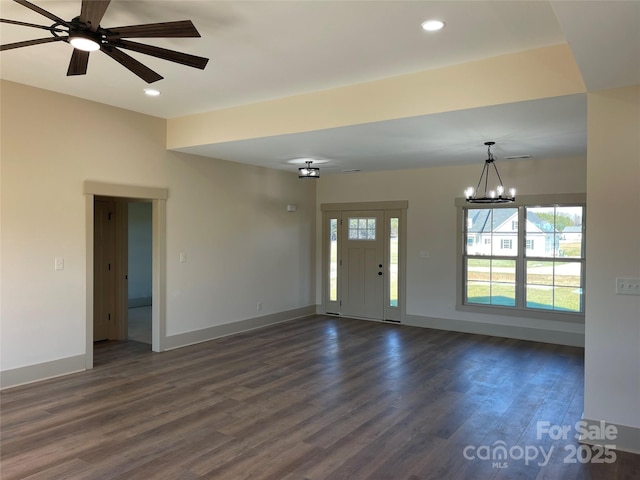 interior space featuring ceiling fan with notable chandelier and dark hardwood / wood-style floors