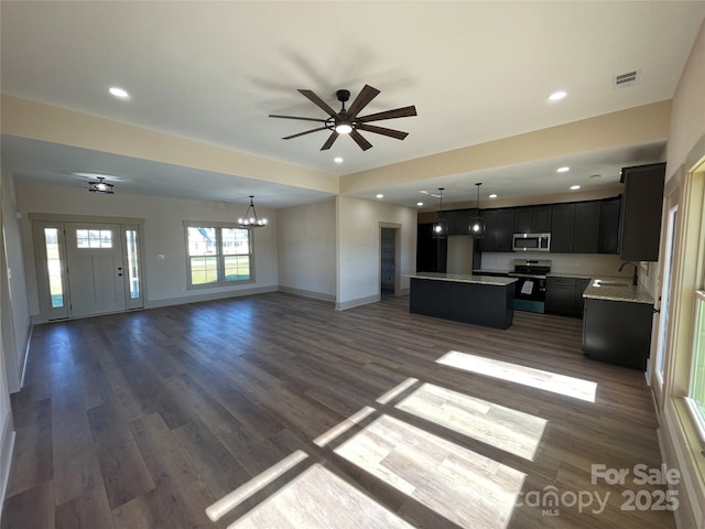 unfurnished living room featuring ceiling fan with notable chandelier, dark hardwood / wood-style flooring, and sink