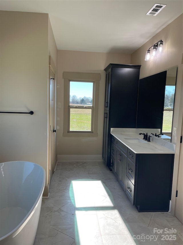 bathroom featuring a washtub and vanity