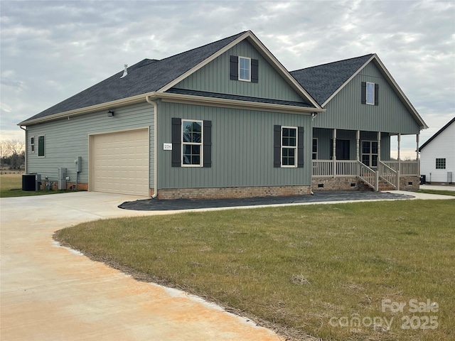 view of front of home with a porch, a garage, a front yard, and cooling unit