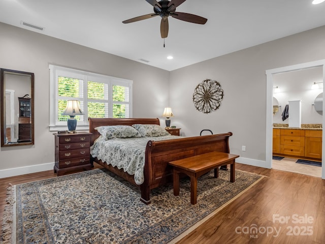 bedroom featuring connected bathroom, ceiling fan, and wood-type flooring