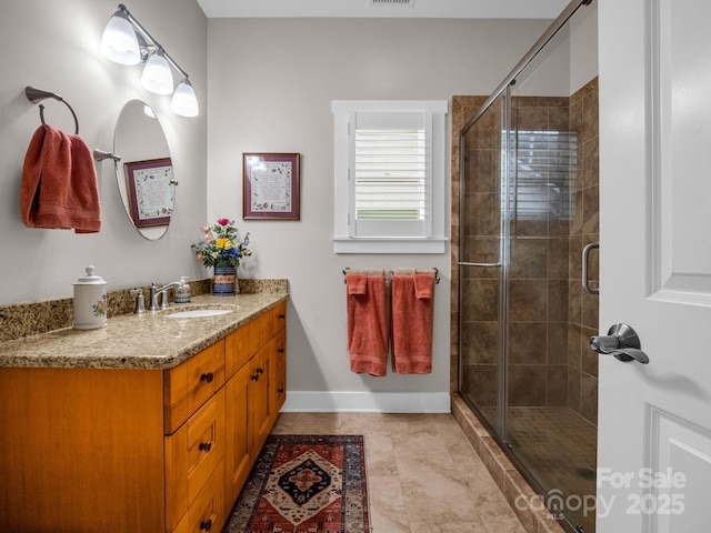 bathroom featuring tile patterned floors, a shower with door, and vanity