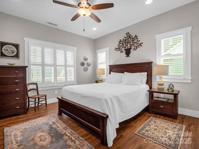 bedroom featuring multiple windows, ceiling fan, and dark hardwood / wood-style floors