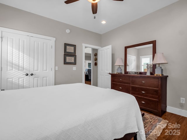 bedroom featuring ceiling fan, dark hardwood / wood-style flooring, and a closet