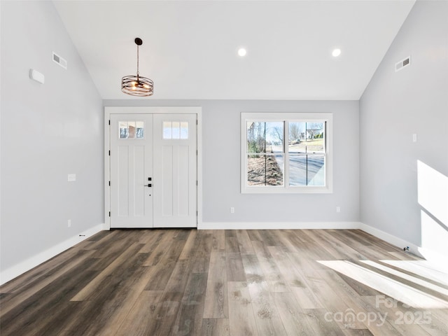 foyer entrance with wood-type flooring, high vaulted ceiling, and a notable chandelier