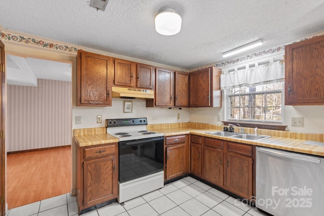 kitchen with sink, a textured ceiling, dishwasher, light tile patterned floors, and electric range