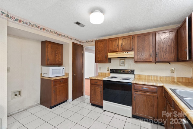 kitchen featuring electric range, dishwasher, light tile patterned floors, a textured ceiling, and sink