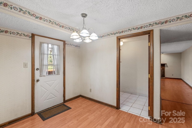 doorway featuring a textured ceiling, light hardwood / wood-style flooring, and a chandelier