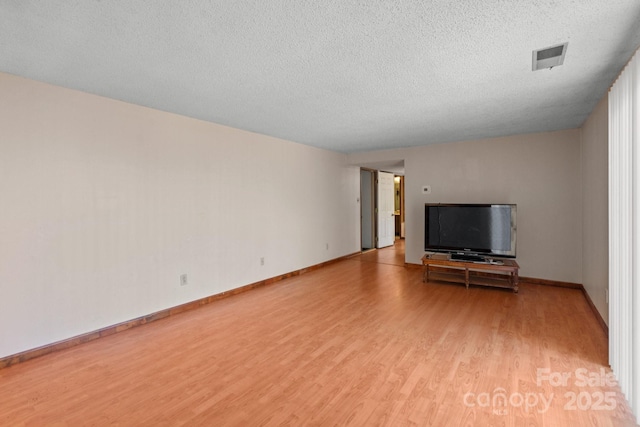 unfurnished living room featuring a textured ceiling and light hardwood / wood-style flooring