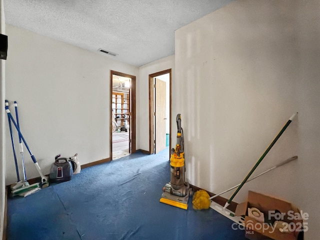 misc room featuring a textured ceiling and carpet