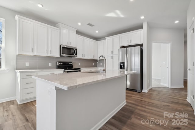 kitchen with white cabinetry, an island with sink, appliances with stainless steel finishes, and sink