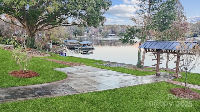 exterior space featuring a water view, a dock, and a lawn