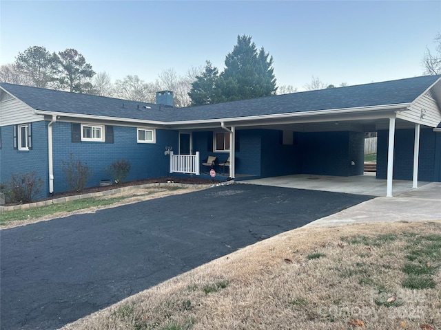 ranch-style home with a porch and a carport