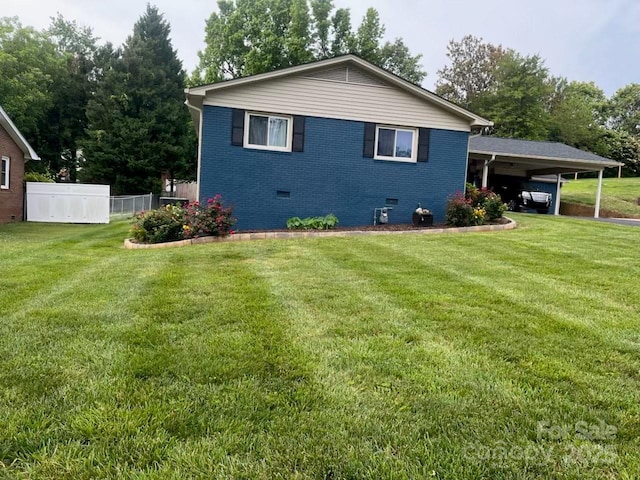 view of side of property featuring a yard and a carport