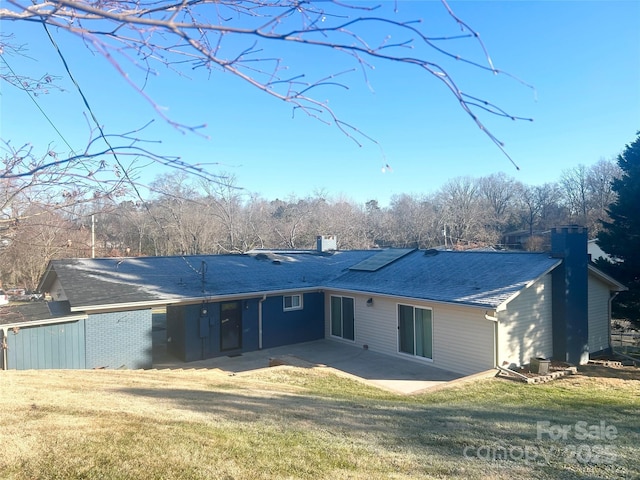 back of property with a lawn and a patio area