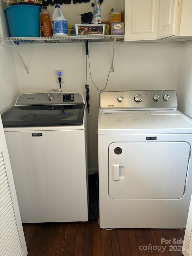 laundry area featuring cabinets, dark hardwood / wood-style floors, and independent washer and dryer