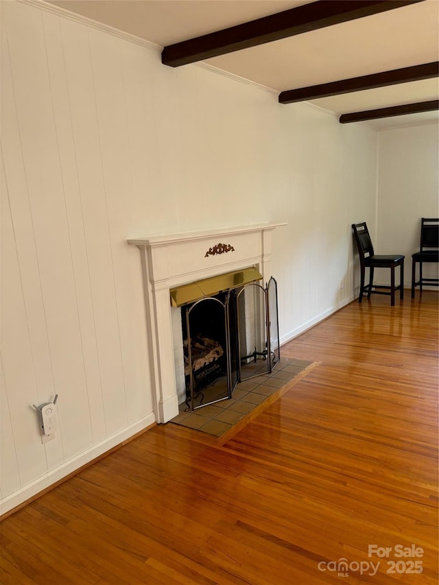 unfurnished living room with beamed ceiling and hardwood / wood-style flooring