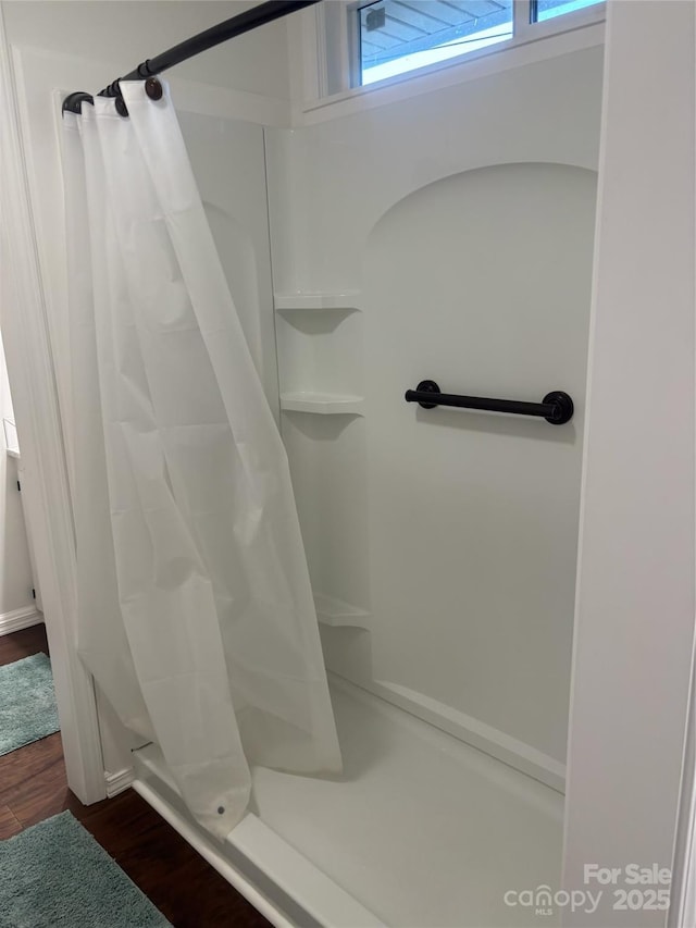 bathroom featuring hardwood / wood-style floors and walk in shower