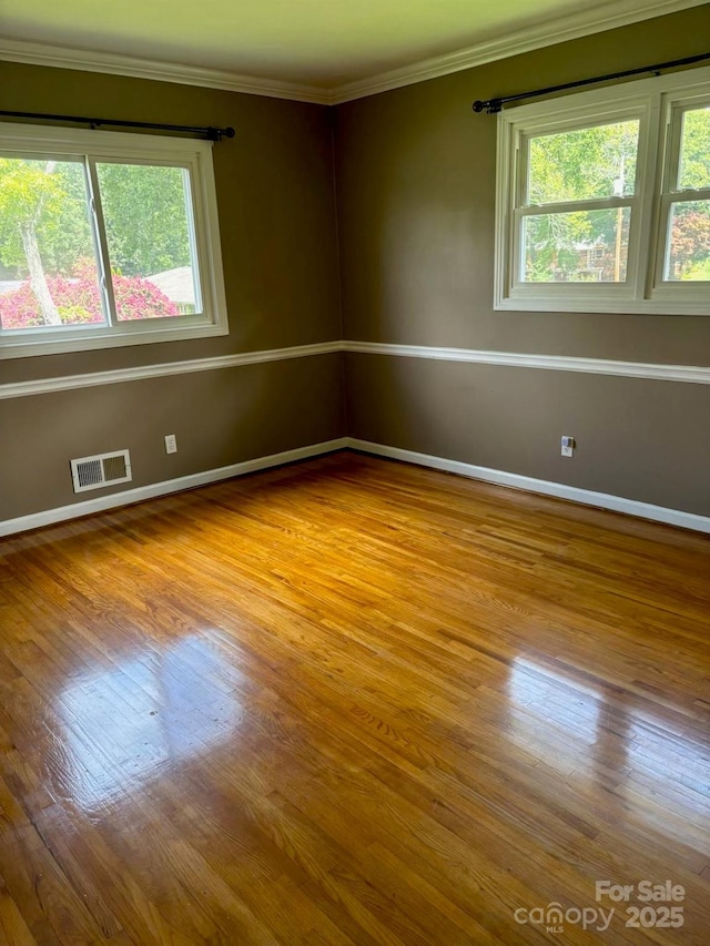 spare room with light hardwood / wood-style floors and crown molding