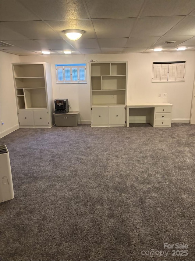 unfurnished living room with dark colored carpet and a drop ceiling