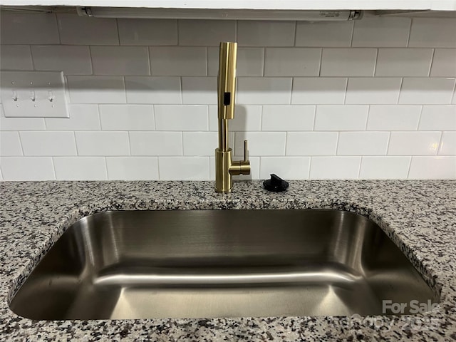 interior details with stone countertops and sink