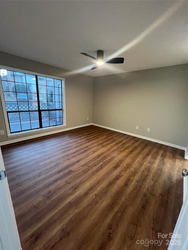 empty room with ceiling fan and dark hardwood / wood-style floors