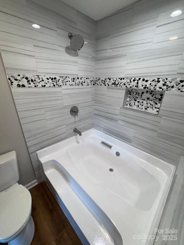 bathroom with toilet, shower / bath combination, and wood-type flooring