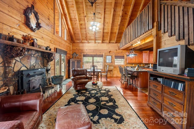 living room with wood walls, a wood stove, high vaulted ceiling, hardwood / wood-style flooring, and wood ceiling