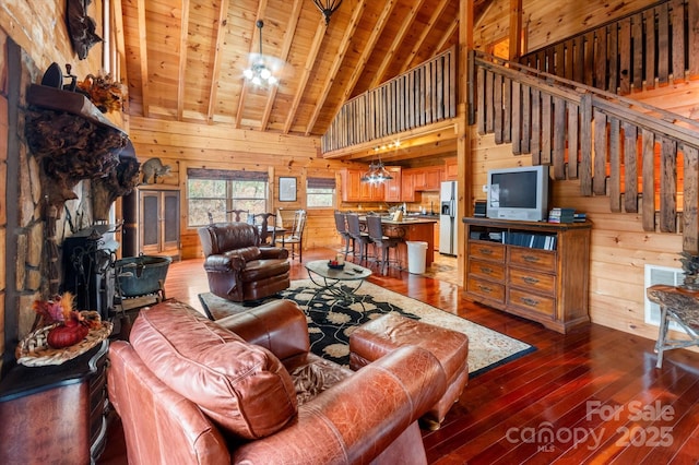 living room with dark wood-type flooring, wooden ceiling, beamed ceiling, high vaulted ceiling, and wood walls