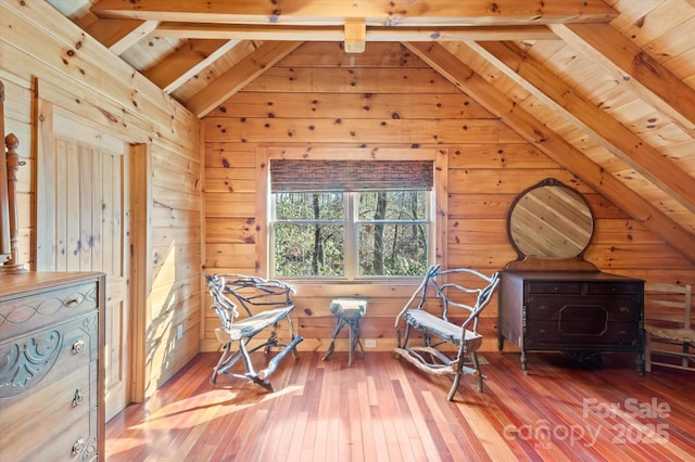 living area with hardwood / wood-style flooring, lofted ceiling with beams, wood walls, and wood ceiling