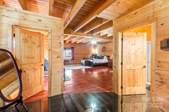 corridor featuring beam ceiling, wood walls, and wooden ceiling