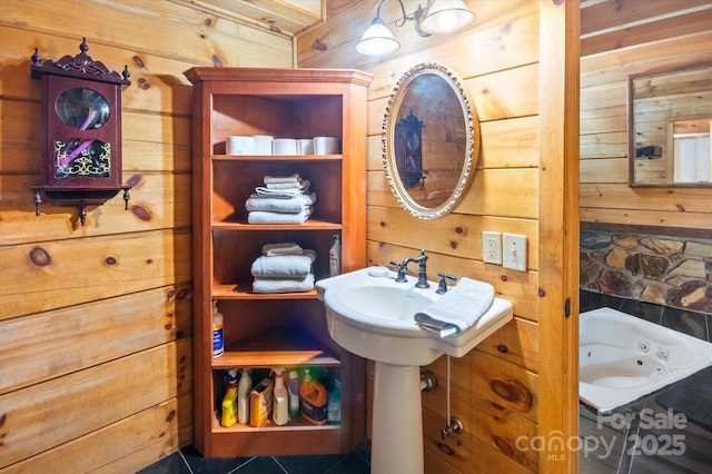 bathroom featuring tile patterned floors, a bathing tub, and wood walls