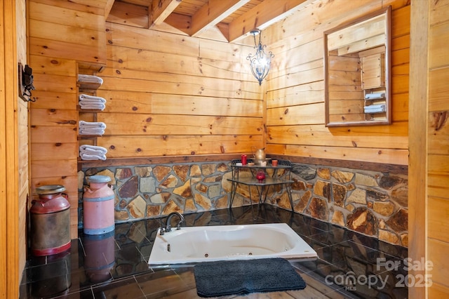 bathroom with beamed ceiling, tiled tub, wooden ceiling, and wooden walls