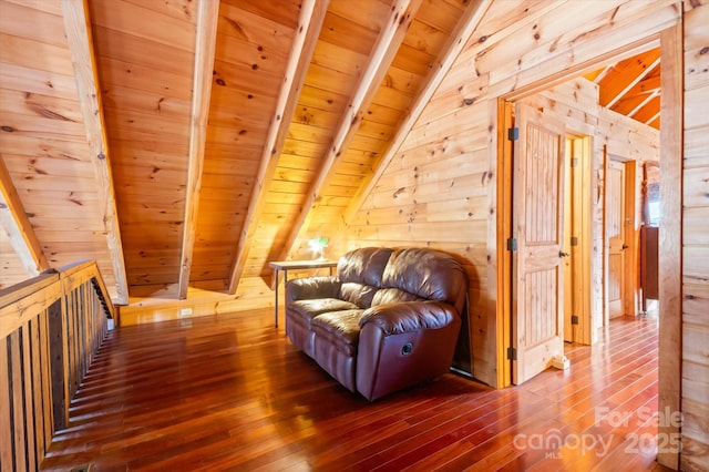 bonus room with lofted ceiling with beams, wood walls, wooden ceiling, and hardwood / wood-style flooring