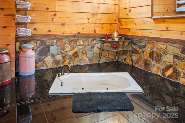 bathroom featuring tiled tub and wooden walls