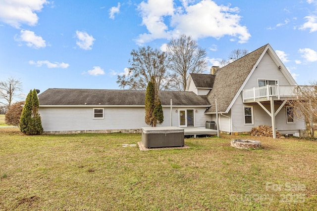 rear view of house featuring central air condition unit, a lawn, an outdoor fire pit, and a wooden deck