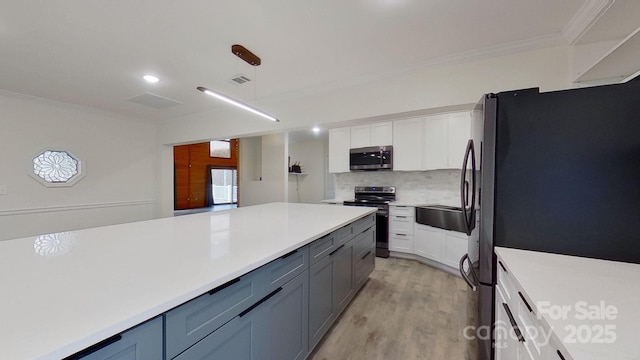 kitchen featuring decorative light fixtures, white cabinetry, appliances with stainless steel finishes, and tasteful backsplash