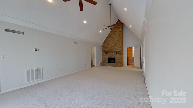 unfurnished living room featuring light carpet, a large fireplace, high vaulted ceiling, and ceiling fan