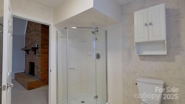 bathroom featuring walk in shower, toilet, and a brick fireplace