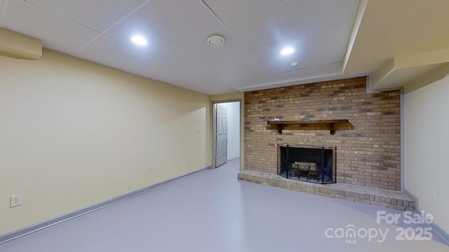 unfurnished living room featuring a paneled ceiling and a fireplace