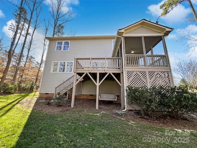 rear view of property featuring a sunroom, a wooden deck, and a lawn