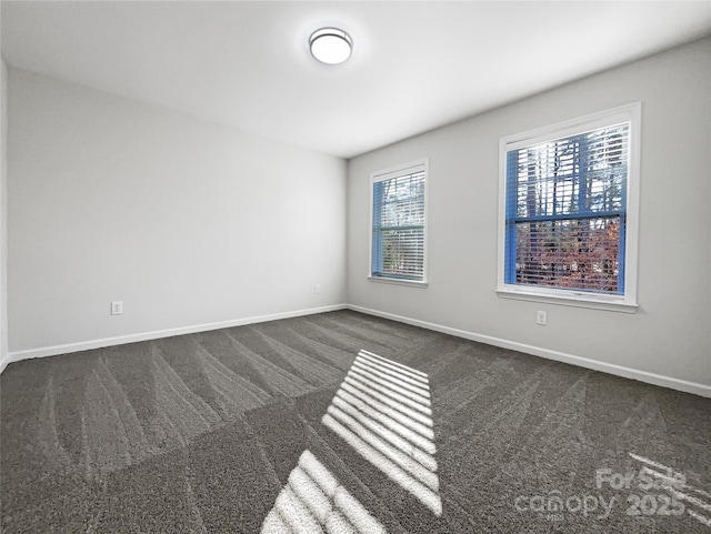 spare room featuring dark colored carpet