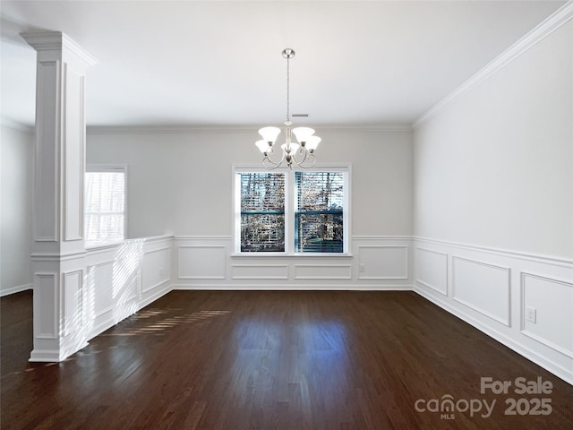 unfurnished dining area featuring dark hardwood / wood-style flooring, crown molding, and a chandelier