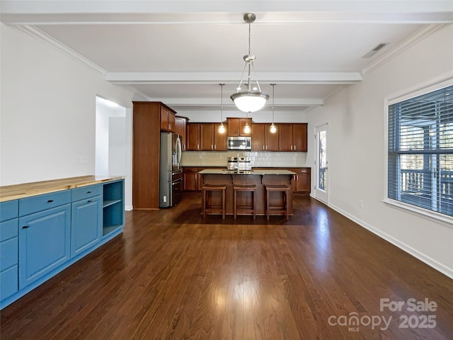 kitchen featuring a center island, beamed ceiling, pendant lighting, decorative backsplash, and appliances with stainless steel finishes