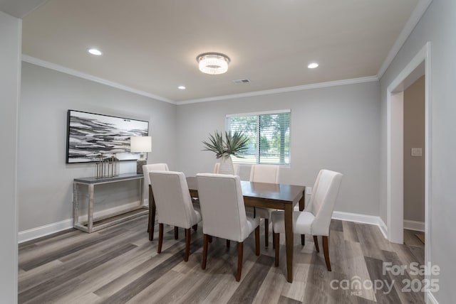 dining room featuring hardwood / wood-style floors and crown molding