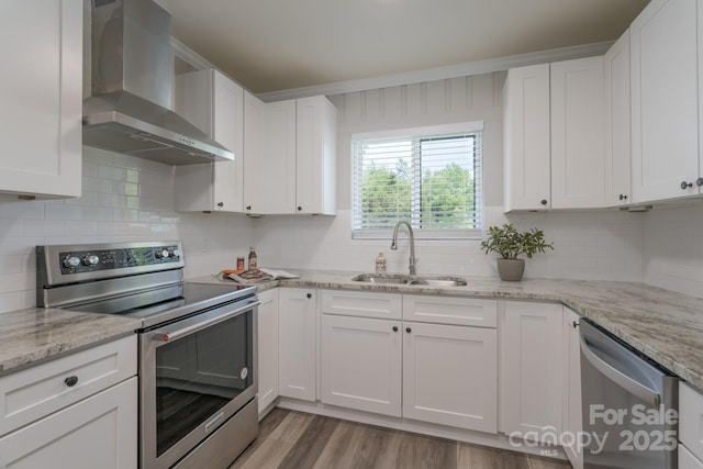 kitchen with white cabinets, sink, wall chimney exhaust hood, and stainless steel appliances