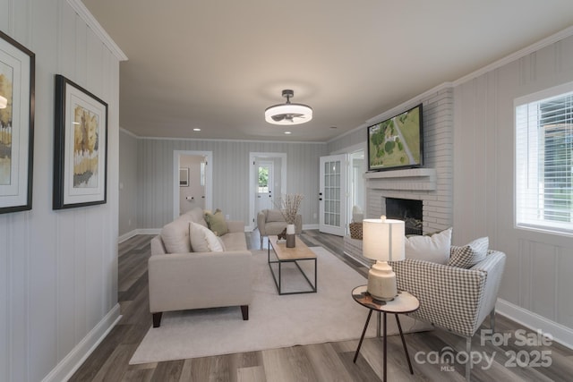 living room with crown molding, dark hardwood / wood-style flooring, and a brick fireplace