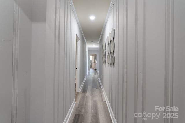 hallway featuring hardwood / wood-style floors and crown molding